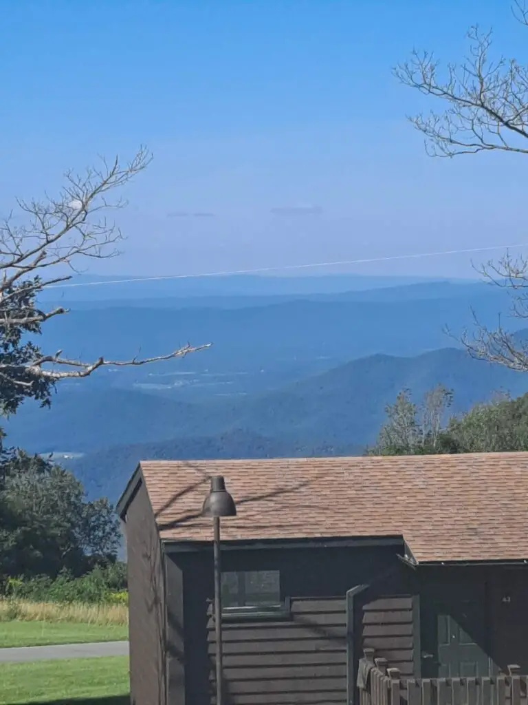 Cabin roof in foreground with deep blue mountains in background